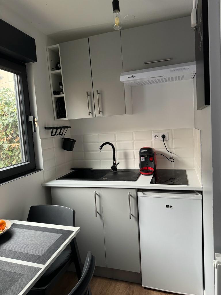 La cuisine équipée : évier, plaque à induction, réfrigérateur et cafetière Tassimo